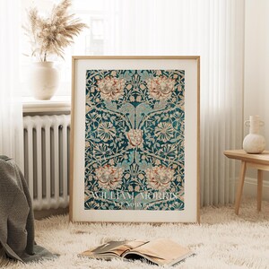 May include: A framed print of a vintage floral pattern in shades of teal, cream, and brown. The print features a repeating design of stylized flowers and leaves. The text "WILLIAM MORRIS ART NOUVEAU" is printed at the bottom of the print.