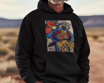 May include: Black hoodie featuring a colorful painting of a person wearing a hat. The painting includes the text "Bill Pickett". The person in the image is wearing a cowboy hat and blue jeans.