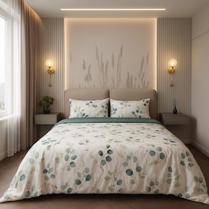 Puede incluir: Una cama con una funda nórdica blanca y fundas de almohada con un estampado de hojas de eucalipto verdes y azules. La cama está hecha con una sábana verde. La habitación tiene una paleta de colores neutros con apliques de pared y un mural decorativo.