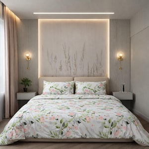 Peut inclure: Ensemble de literie floral avec une housse de couette blanche et des taies d'oreiller ornées de fleurs roses et de feuilles vertes. La chambre a une palette de couleurs neutres avec une tête de lit beige et un décor mural assorti.
