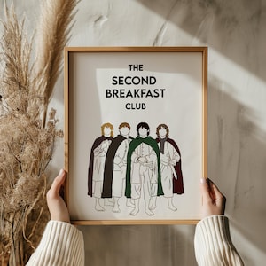Könnte beinhalten: Ein weißer gerahmter Druck mit dem Text "The Second Breakfast Club" und einer Strichzeichnung von fünf Personen in Umhängen.