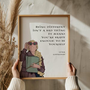 Puede incluir: Una impresi&oacute;n enmarcada en blanco con una cita de Luna Lovegood de la serie Harry Potter. La cita dice "Ser diferente no es algo malo. Significa que eres lo suficientemente valiente para ser t&uacute; mismo." La impresi&oacute;n presenta una ilustraci&oacute;n de dibujos animados de Luna Lovegood con sus gafas caracter&iacute;sticas.