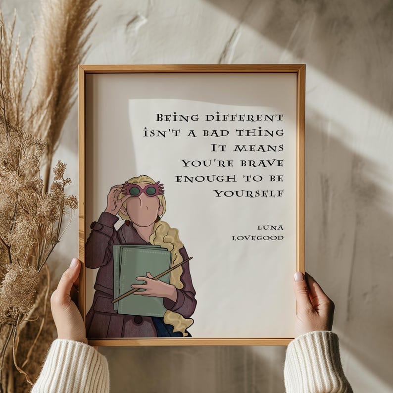 Puede incluir: Una impresi&oacute;n enmarcada en blanco con una cita de Luna Lovegood de la serie Harry Potter. La cita dice "Ser diferente no es algo malo. Significa que eres lo suficientemente valiente para ser t&uacute; mismo." La impresi&oacute;n presenta una ilustraci&oacute;n de dibujos animados de Luna Lovegood con sus gafas caracter&iacute;sticas.