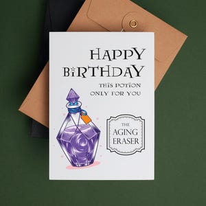 May include: A white card with the text "Happy Birthday" and "This potion only for you" in black. A purple potion bottle with a crystal stopper and a label that says "The Aging Eraser" is illustrated on the card.