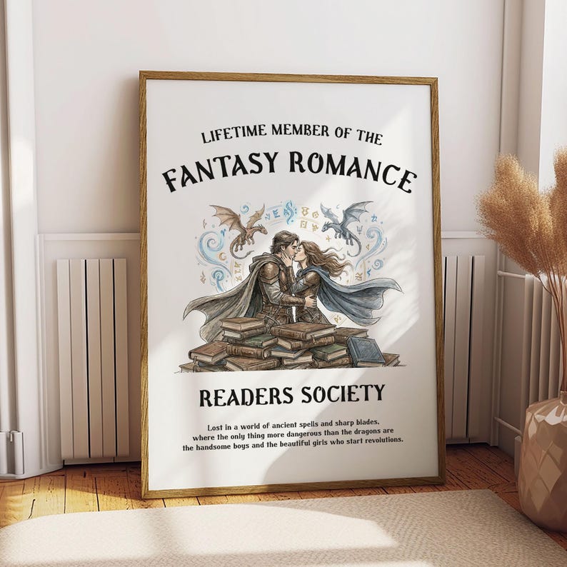 May include: A framed print with the text "LIFETIME MEMBER OF THE FANTASY ROMANCE READERS SOCIETY." The image features a couple kissing, dragons, and stacks of books. The quote reads, "Lost in a world of ancient spells and sharp blades..."