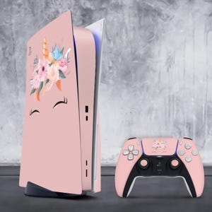 May include: Pink Playstation 5 console with a unicorn and floral design on the front panel. The console is next to a pink Playstation 5 controller with the same design.