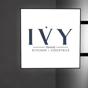 May include: A white sign with black text that reads "IVY Detroit KITCHEN + COCKTAILS".