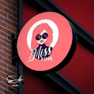 May include: A pink and black round sign with a cartoon illustration of a woman with pink hair wearing sunglasses and a black turtleneck. The text "Miss Pink" is written in a cursive font below the illustration.