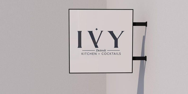 May include: A white sign with black lettering that reads "IVY Detroit KITCHEN + COCKTAILS".