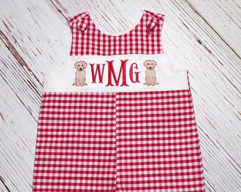 May include: Red and white gingham romper with embroidered puppies and the initials "WMG" in red. The romper has button closures at the shoulders and snaps at the bottom. A classic, preppy style.