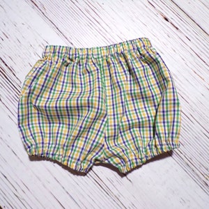 May include: Yellow, green, and purple plaid baby bloomers with elastic waistband.