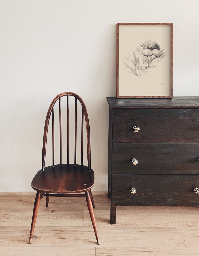 Vintage Graphite Pencil Drawing of a blooming flower, frame and displayed over a dark brown drawer cabinet beside an antique chair. | Dear Alice Printable Art