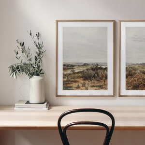 Set of Two Printable Farmhouse Wall Art featuring a landscape in muted earthy tones. Downloadable pair of landscape prints hung on the wall of a neutral and calm farmhouse office decor. | Dear Alice Art