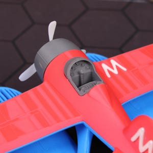 Close-up of floating seaplane model featuring detailed 3D printed design, shown on a tabletop as a unique desk or shelf decor item. Ideal for aviation enthusiasts and kids who love aircraft toys, it serves as both an educational STEM toy and a charming display piece. Great as a Christmas holiday gift, Halloween decoration, or collectible aviation-themed item. This model helps introduce kids to water science concepts while also providing hours of bathtub or pool fun.