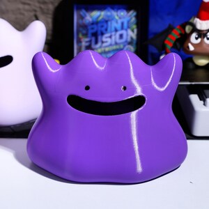 Fun gaming-inspired tissue box with a playful monster design. Features 3D printed construction and squishy texture for added tactile experience. A great gift for gamers and monster fans, perfect for home or office decor.