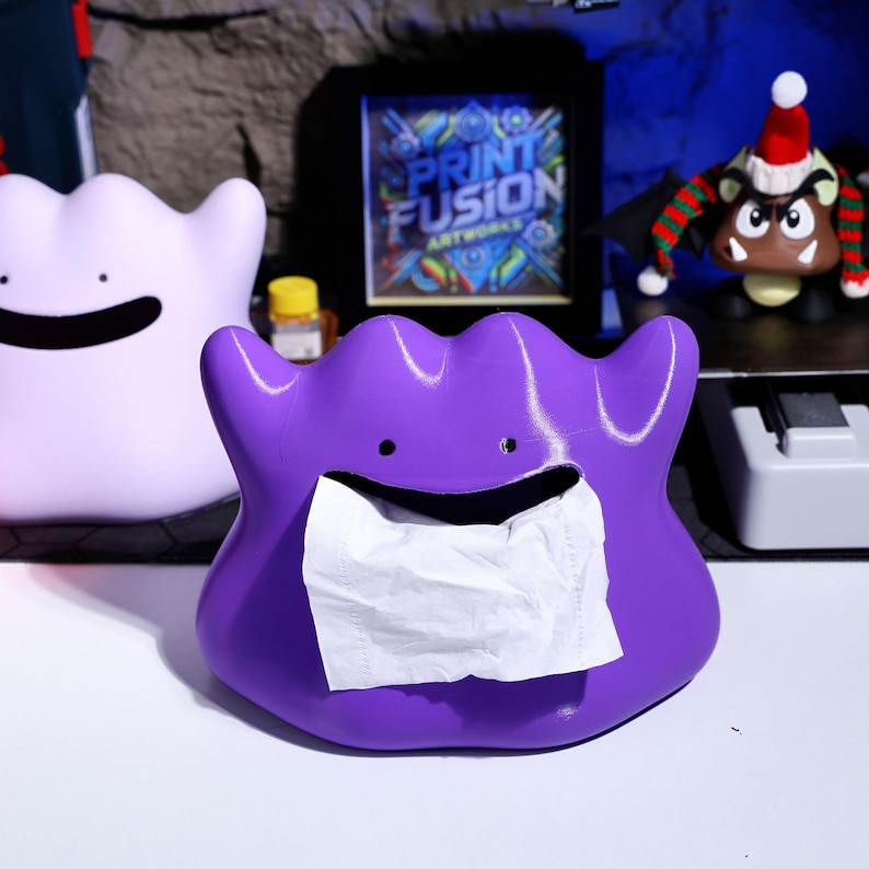 3D printed shape-shifting monster tissue box with a soft, squeezable texture and magnetic base for stability. Perfect for gaming enthusiasts, home office decor, and unique fan gifts. Adds a playful touch to any space.