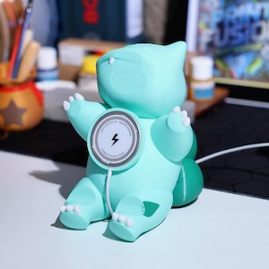 Adorable green creature charger that works as both a MagSafe charging station and phone stand. Great for gaming fans and collectible decor. Perfect holiday gift for anyone who loves quirky, nature-inspired gadgets and eco-friendly phone accessories.