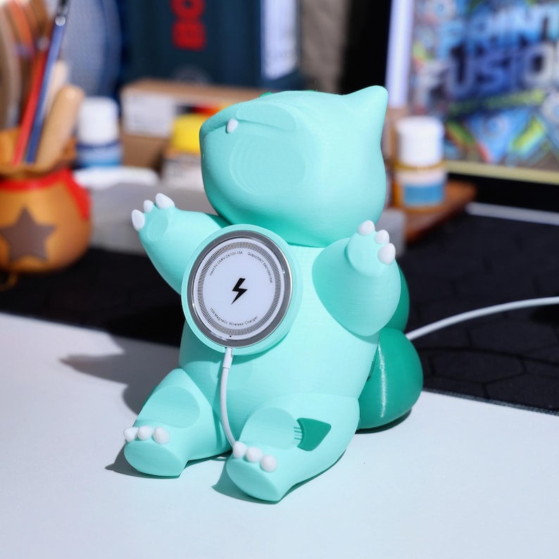 Adorable green creature charger that works as both a MagSafe charging station and phone stand. Great for gaming fans and collectible decor. Perfect holiday gift for anyone who loves quirky, nature-inspired gadgets and eco-friendly phone accessories.