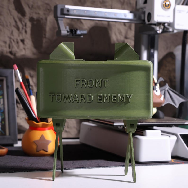 Military-inspired Bluetooth speaker, realistic 3D print claymore design, veteran gift idea, claymore mine decor, unique sound system, office decor, personalized audio device, claymore-inspired speaker, military gift for men, claymore desktop