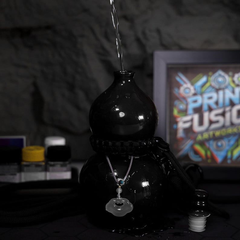 May include: A black ceramic gourd with a silver chain and a white jade pendant. Water is being poured into the gourd from above.