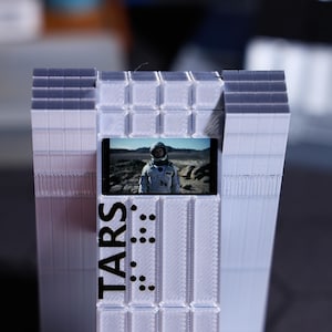 Customizable TARS Robot ornament for Christmas, New Year or birthday gifts, great for movie collectors. Sci-fi fans will love the personalized messages, dynamic standby animations, and classic space adventure scenes. Perfect for desk.