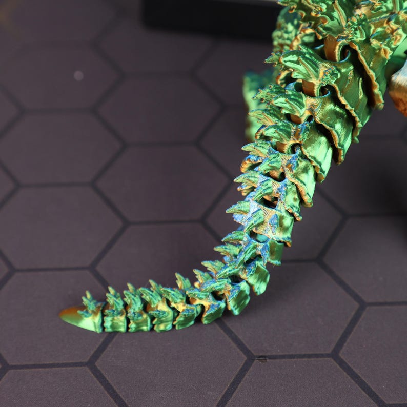 Detail shot of the articulated limbs and joint segments on the Godzilla collectible figure, highlighting the precision of the 3D printing and electroplating process. The chrome finish reflects various shades of green and blue, enhancing the visual depth of the figure. Ideal for showcasing the realistic motion range of the toy, this photo emphasizes how well the figure serves as a gift for gamers, boys, or collectors who value poseability and craftsmanship in monster toys.