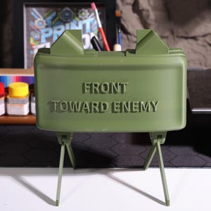 Claymore design Bluetooth speaker, military-inspired decor, realistic claymore mine, high-quality 3D printed speaker, rugged decor piece, veteran gift, personalized Bluetooth sound, unique claymore decor, collectible speaker, militarythemed Bluetooth