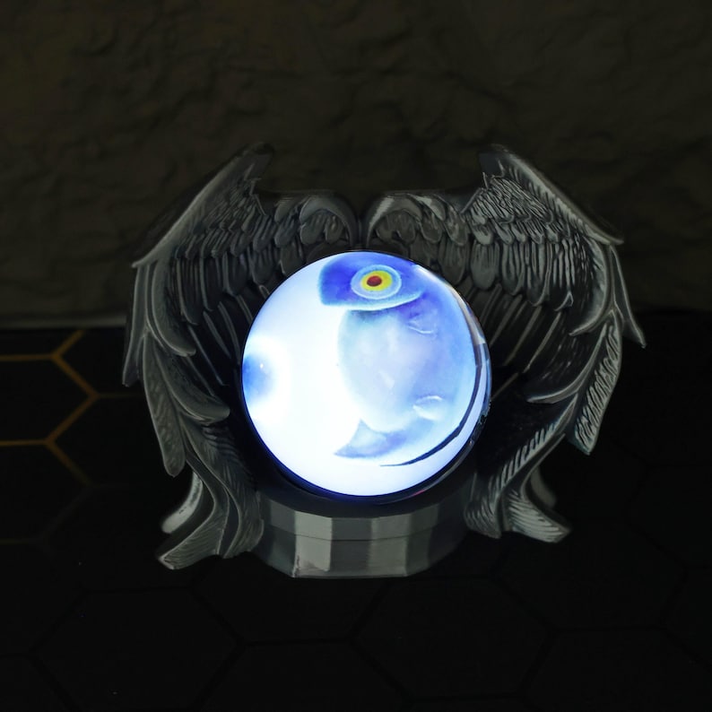 The magic orb LED display sits on a shelf surrounded by Fullmetal Alchemist and Naruto memorabilia, highlighting its customizable image projection and gamer-friendly size. With its USB-C charging feature and eerie yet stunning glow, this crystal ball is a must-have for anime collectors, fantasy fans, and those looking to give a unique holiday gift for him.