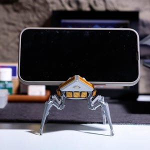 Phone holder with rotating head, Apex-themed phone stand for desktop use, great as a gift for Apex Legends gamers, eco-friendly and sustainable material, ideal for keeping your phone visible during gaming sessions.