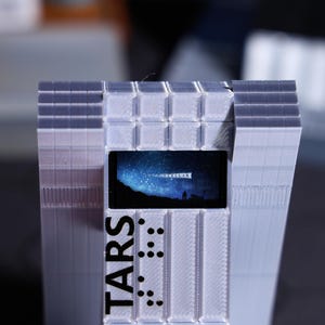 Sci-fi movie fan gift, TARS Robot desktop decoration with personalized holiday message. Customizable screen with classic space movie scenes, unique home decor for fans, collectible ornament for sci-fi enthusiasts, perfect for holiday gifting.
