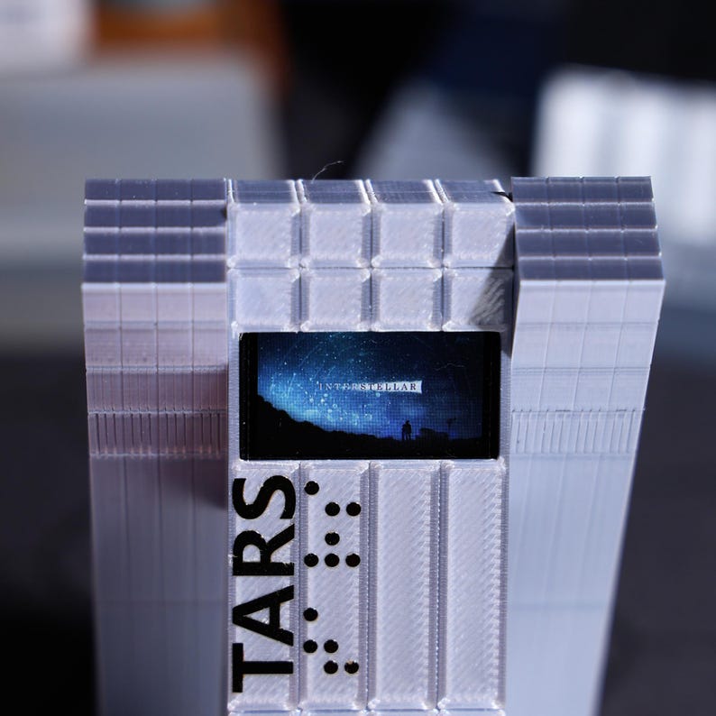Sci-fi movie fan gift, TARS Robot desktop decoration with personalized holiday message. Customizable screen with classic space movie scenes, unique home decor for fans, collectible ornament for sci-fi enthusiasts, perfect for holiday gifting.