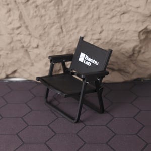 Artistic shot of the miniature film set from above, showing the layout and proportions of the chair and clapperboard together. This collectible is a tribute to the art of filmmaking and serves as a motivational symbol for creatives. Whether used as a photography prop, shelf accent, or personal keepsake, this set is an eye-catching piece for cinema fans, directors, and storytellers. The compact design ensures it fits perfectly in a variety of spaces, from home offices to studio desks.