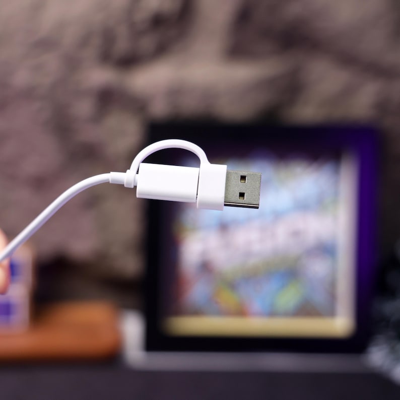 May include: White USB cable with a white connector. The connector has a silver metal tip with two small holes.