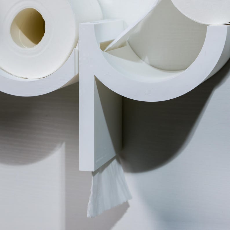 May include: White wall-mounted paper towel holder with two rolls of paper towels and a dispenser for facial tissues.