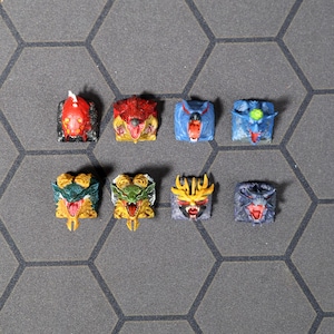 Puede incluir: Ocho teclas diferentes con caras de monstruos coloridos. Las teclas est&aacute;n hechas de pl&aacute;stico y tienen una variedad de colores, incluyendo rojo, azul, verde, amarillo y negro.