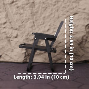 Angle shot of the miniature folding director’s chair, highlighting the printed logo on the fabric and the clean structure of the 3D print. This item is a great gift for aspiring directors, producers, and anyone studying or working in film. It serves as a daily reminder of your creative vision and love for cinema. Perfect for holiday gifting, birthdays, or special occasions for those passionate about storytelling and film production aesthetics.