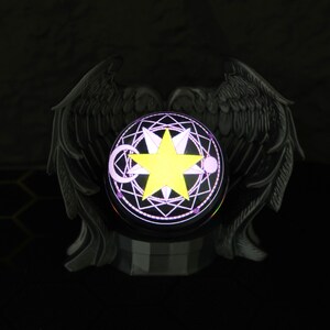 The magic orb LED display sits on a shelf surrounded by Fullmetal Alchemist and Naruto memorabilia, highlighting its customizable image projection and gamer-friendly size. With its USB-C charging feature and eerie yet stunning glow, this crystal ball is a must-have for anime collectors, fantasy fans, and those looking to give a unique holiday gift for him.