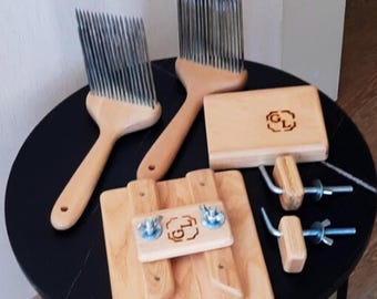 May include: A collection of wooden fiber tools for crafting. The set includes two large wool combs with metal tines, two wooden blocks with metal hardware, and a small wooden block with a logo. The tools are arranged on a black table.
