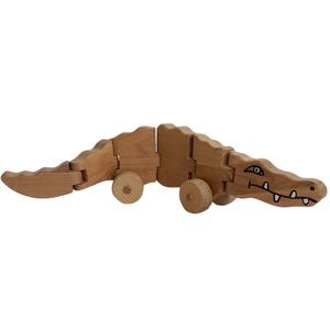 children&#39;s toy, moving crocodile on wheels, handmade, made of wood, covered with ecological varnish, moves in two directions
