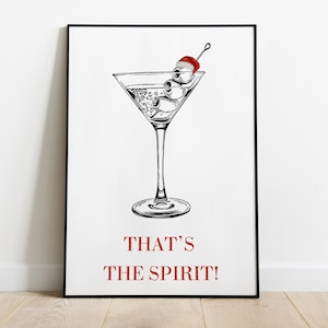 Peut inclure: Une illustration en noir et blanc d'un verre à martini avec deux yeux et une cerise rouge sur un cure-dent. Le texte "THAT'S THE SPIRIT!" est sous le verre.