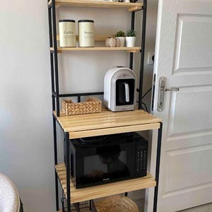 Könnte beinhalten: Schwarzes Metallregal mit Holzböden. Die Regale sind mit verschiedenen Gegenständen gefüllt, darunter eine Kaffeemaschine, eine Mikrowelle und Aufbewahrungsbehälter. Das Schild über dem obersten Regal lautet "coffee bar love is brewin".