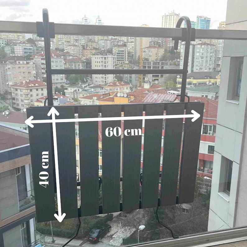 May include: Black metal balcony table with slatted wood top. The table measures 40 cm by 60 cm.