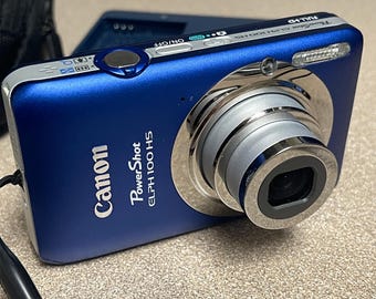 Fotocamera digitale Canon PowerShot ELPH 100 HS blu cobalto da 12,1 megapixel. La maggior parte degli accessori sono inclusi, nella scatola originale e in ottime condizioni.