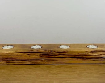 以下が含まれることがあります： 4つのキャンドル用のくぼみがある、素朴な木製キャンドルホルダー。ホルダーは、ざらざらとした質感のある自然な木で作られています。