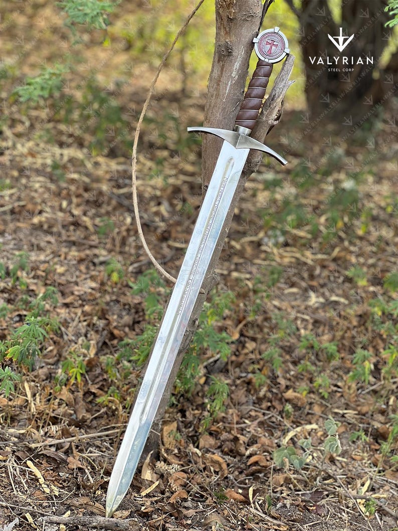 The Accolade Sword of the Knights Templar is a magnificent weapon of ceremony and devotion — a blade worthy of a Grand Master himself. Named “The Accolade,” this sword symbolizes the moment of knighthood, where a loyal member of the Order would be dubbed in service of faith. Its Latin inscription, “Non Nobis, Domine, Non Nobis, Sed Nomini Tuo Da Gloriam” defines the creed and humility of the Templars who shaped medieval history through faith and steel.