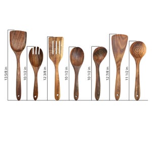Op de afbeelding: Een set van zeven houten keukengerei, waaronder een spatel, een sleuflepel en een opscheplepel. Het langste keukengerei meet 34.6 cm. Het keukengerei is gemaakt van lichtbruin hout en is geplaatst tegen een witte achtergrond.