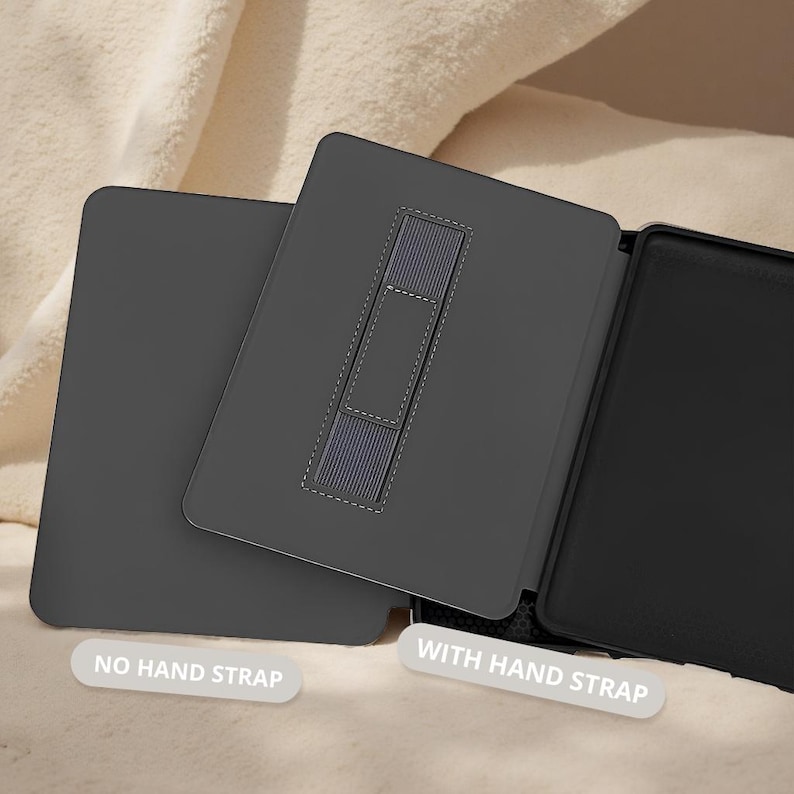 May include: A dark gray tablet case with a hand strap. The case is shown open and closed, with the text "NO HAND STRAP" and "WITH HAND STRAP" on the image. The case is made of a smooth material and has a contrasting gray hand strap.