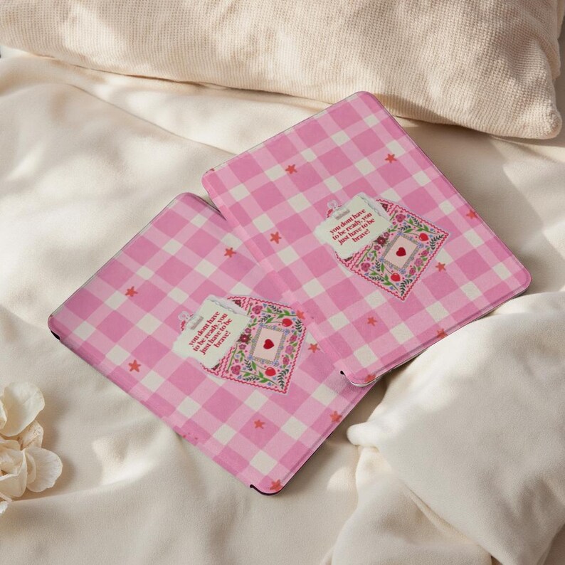 May include: Two pink and white gingham notebooks. Each notebook features a decorative patch with a heart and the text "you don't have to be ready, you just have to be brave!"