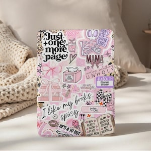 May include: A pink and white book cover with various stickers and text. The cover features phrases like "Just one more page," "I like my books spicy," and "In my book of course... not mentally." Other graphics include bows, hearts, and a skeleton.