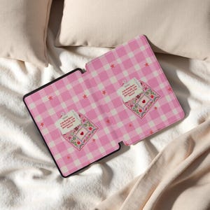 May include: Tablet case with a pink and white gingham design and a black border. It has two embroidered patches with flowers, a heart, and the text "You don't have to be ready, you just have to be brave!"